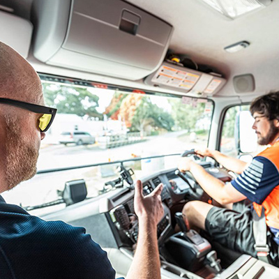 Driving assessor coaching an HGV driver in the cab